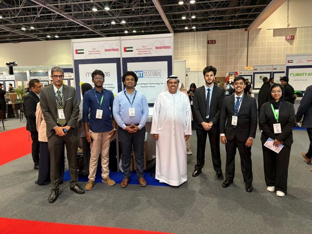 Group photo of the team with visitors in front of the stand